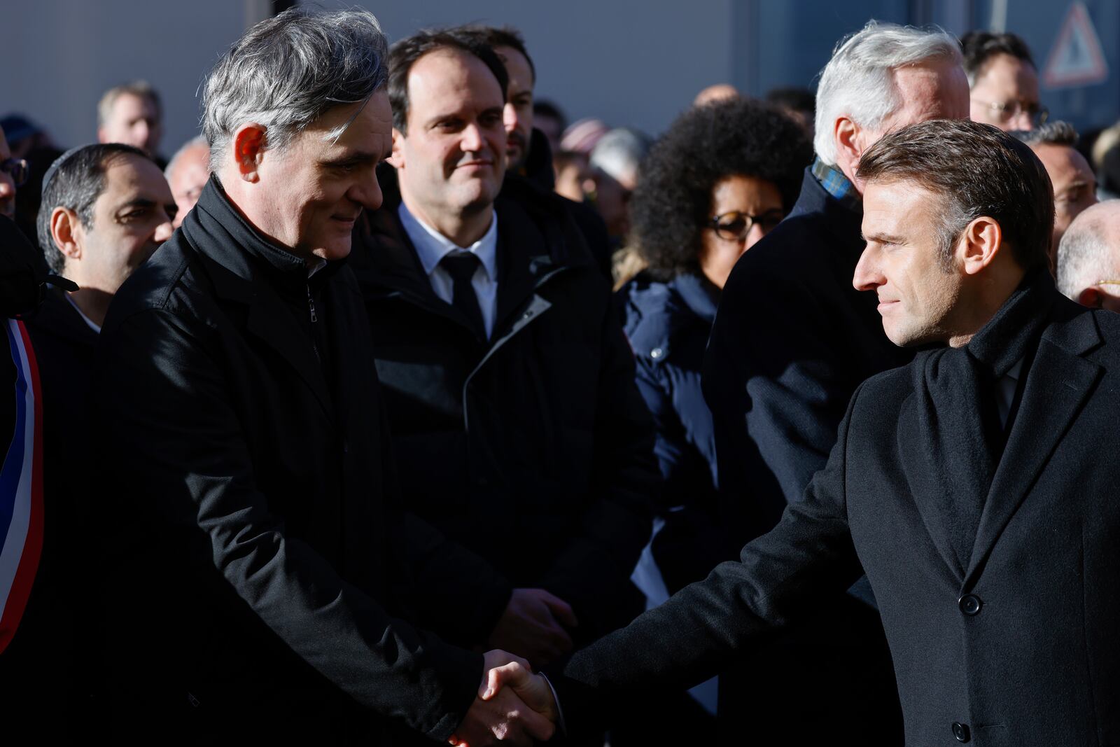 French President Emmanuel Macron, right, shakes hands with Laurent Sourisseau, known as "Riss", publishing director of French satirical magazine "Charlie Hebdo" during commemorations marking 10 years since an Islamist attack on the Charlie Hebdo satirical newspaper and the Hypercacher jewish supermarket, outside the weekly's former offices in Paris Tuesday Jan. 7, 2025. (Ludovic Marin, Pool via AP)