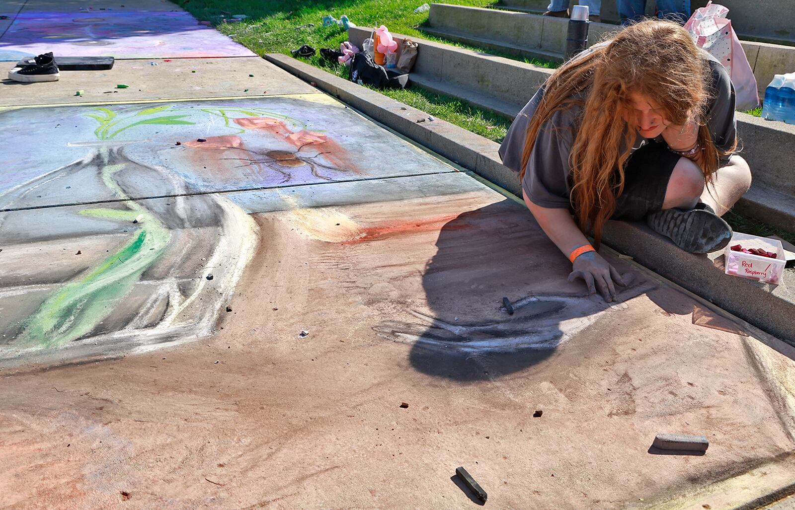 Bryleigh Perdue works on her chalk art Saturday, Oct. 5, 2024 during ChalkFest at National Road Commons Park in downtown Springfield. Dozens of amateur and professional artists from around the area showed off their skill on the sidewalks and streets around the park. ChalkFest also featured live music, food trucks and creative activities for the kids. BILL LACKEY/STAFF