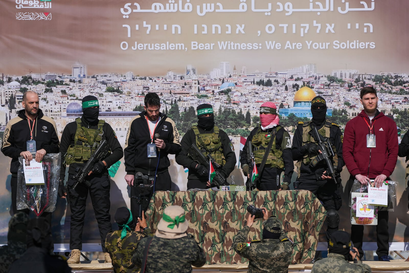 Israeli hostages Iair Horn, 46, left, Sagui Dekel Chen, 36, center left, and Alexander Troufanov, 29, right, are escorted by Hamas and islamic Jihad fighters as they are handed over to the Red Cross in Khan Younis, Gaza Strip, Saturday, Feb. 15, 2025. (AP Photo/Abdel Kareem Hana)