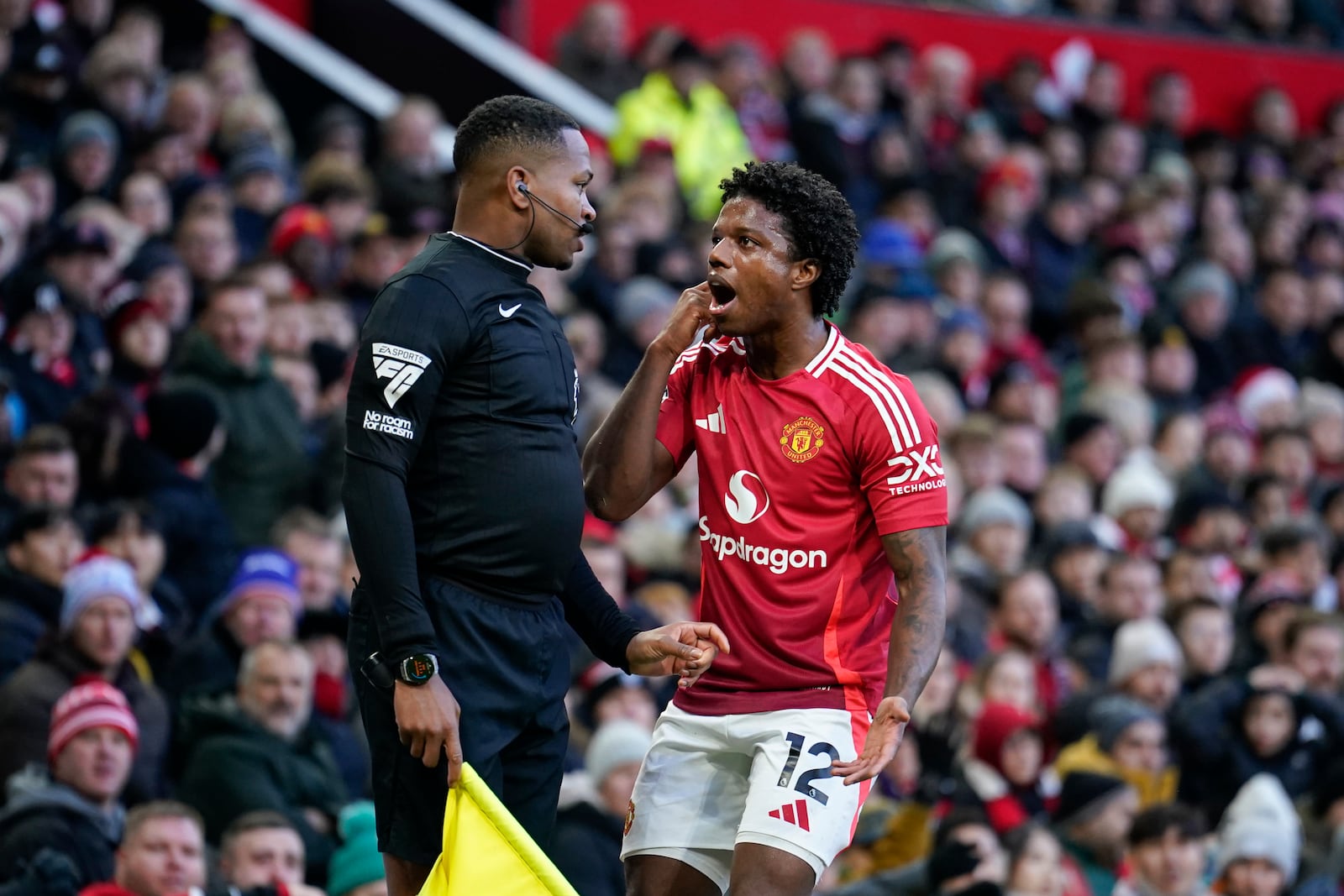 Manchester United's Tyrell Malacia argues with line referee Akil Howson after a foul on Bournemouth's Adam Smith during the English Premier League soccer match between Manchester United and Bournemouth at the Old Trafford stadium in Manchester, England, Sunday, Dec. 22, 2024. (AP Photo/Dave Thompson)