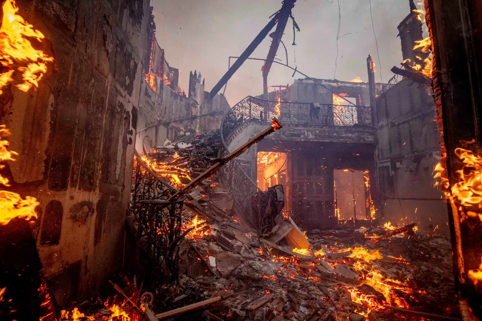 The Palisades Fire burns a residence in the Pacific Palisades neighborhood of Los Angeles, Tuesday, Jan. 7, 2025. (AP Photo/Ethan Swope)