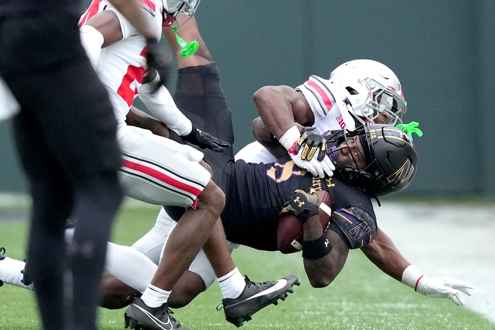 Northwestern wide receiver A.J. Henning catches a pass from quarterback Jack Lausch as Ohio State safety Caleb Downs during the first half of an NCAA college football game at Wrigley Field on Saturday, Nov. 16, 2024, in Chicago. (AP Photo/Charles Rex Arbogast)