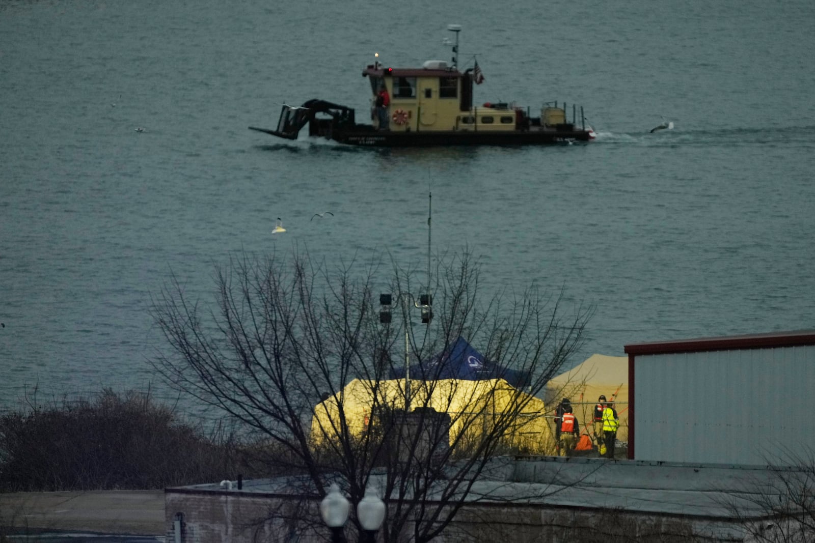 Emergency vehicles are seen across the Potomac River near Ronald Reagan Washington National Airport, Friday, Jan. 31, 2025, in Washington. (AP Photo/Carolyn Kaster)