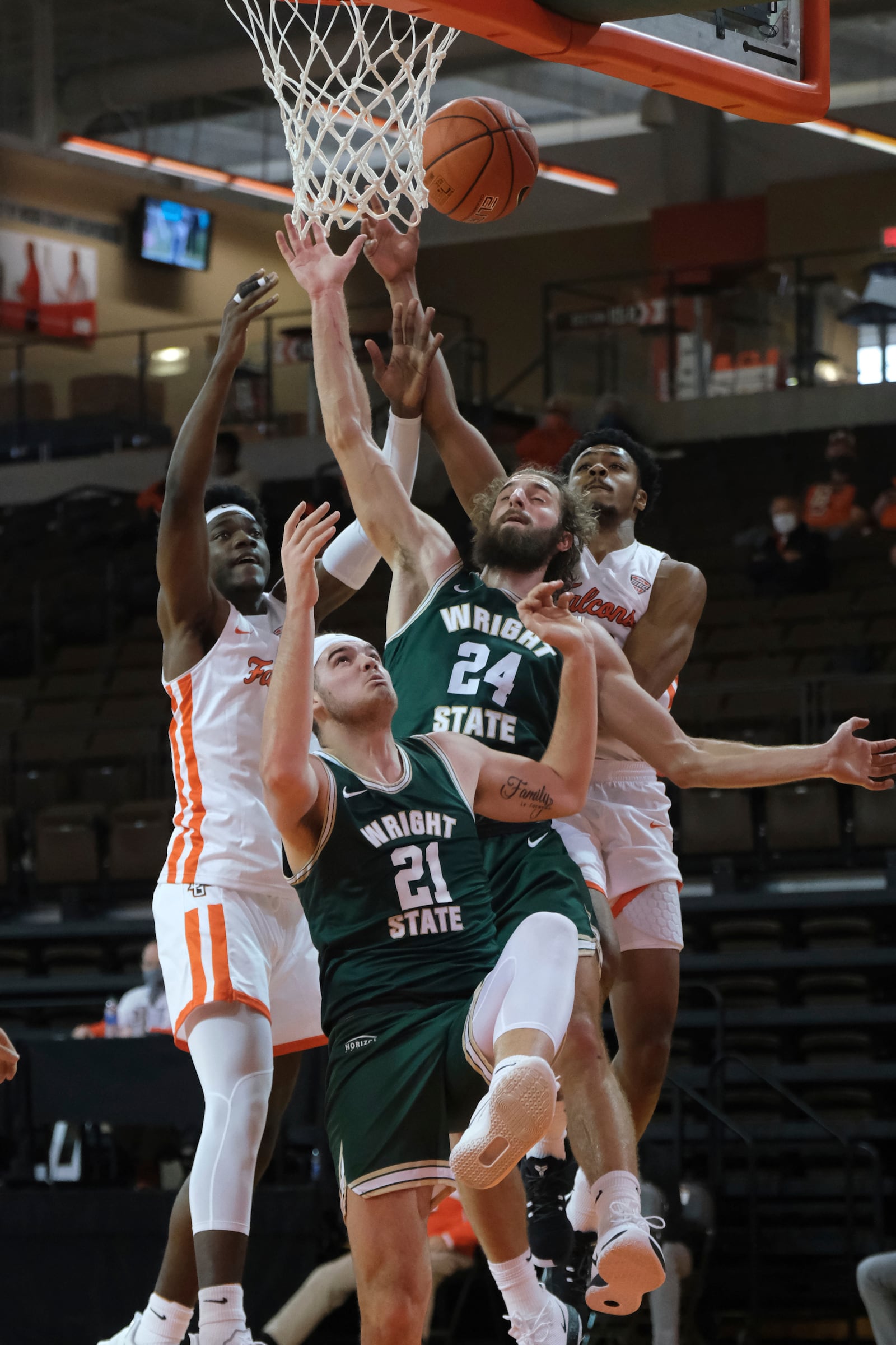 Bowling Green's Cam Young, right, and Jacob Washington, left,  battle for a rebound against Wright State's Tim Finke (24) and Grant Basile (21) during the first half of an NCAA college basketball game Sunday, Dec. 13, 2020, in Bowling Green, Ohio.  (J.D. Pooley/Sentinel-Tribune via AP)