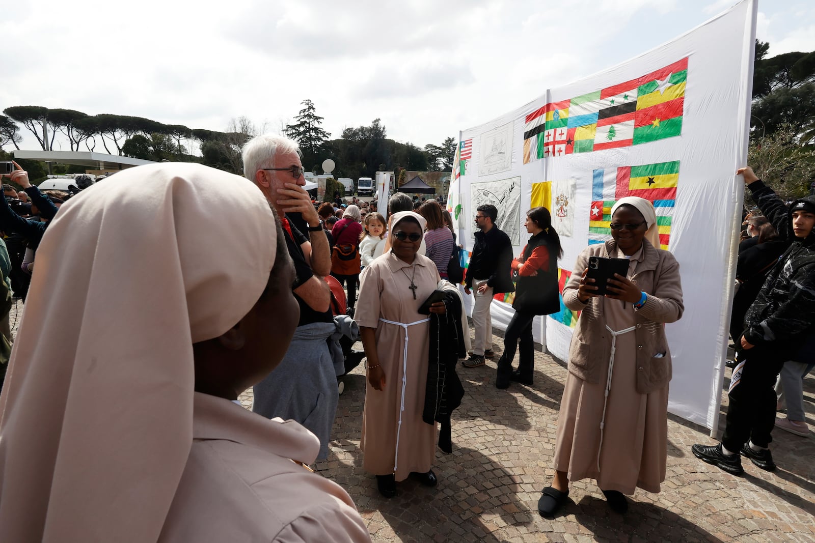 Faithfuls and nuns wait a Pope Francis appearing at a window of the Agostino Gemelli Polyclinic in Rome, Sunday, March 23, 2025, for the first time after being admitted on Feb. 14 with bronchitis that afterward worsened into bilateral pneumonia. (AP Photo/Riccardo De Luca)