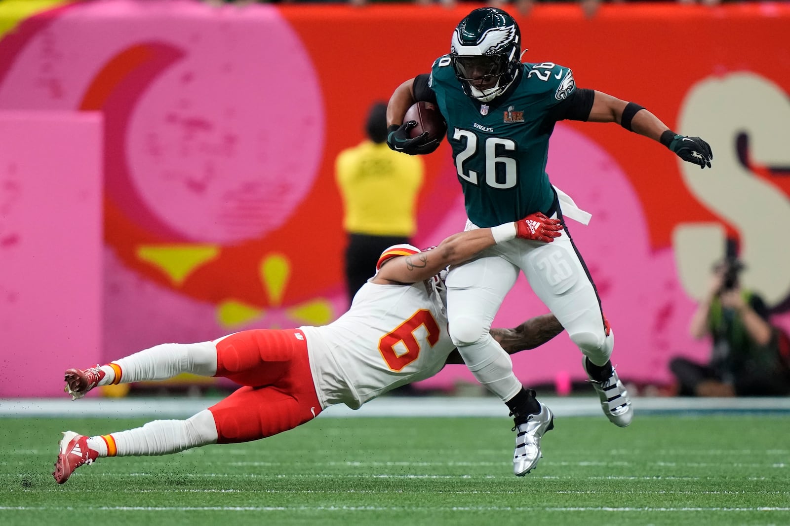 Philadelphia Eagles running back Saquon Barkley (26) tries to elude the tackle of Kansas City Chiefs safety Bryan Cook (6) during the first half of the NFL Super Bowl 59 football game, Sunday, Feb. 9, 2025, in New Orleans. (AP Photo/Frank Franklin II)