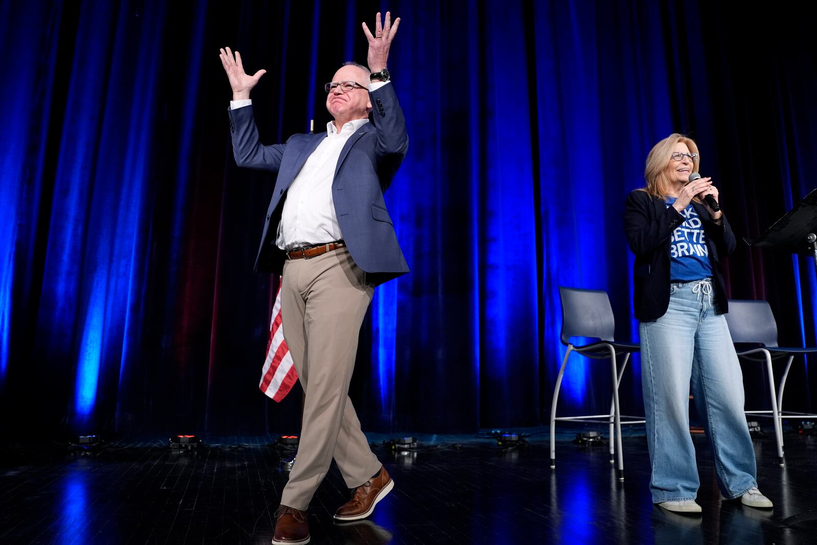 Minnesota Gov. Tim Walz, left, is introduced onstage by Rita Hart, chair of the Iowa Democratic speak at a town hall event at Roosevelt High School, Friday, March 14, 2025, in Des Moines, Iowa. (AP Photo/Matthew Putney)