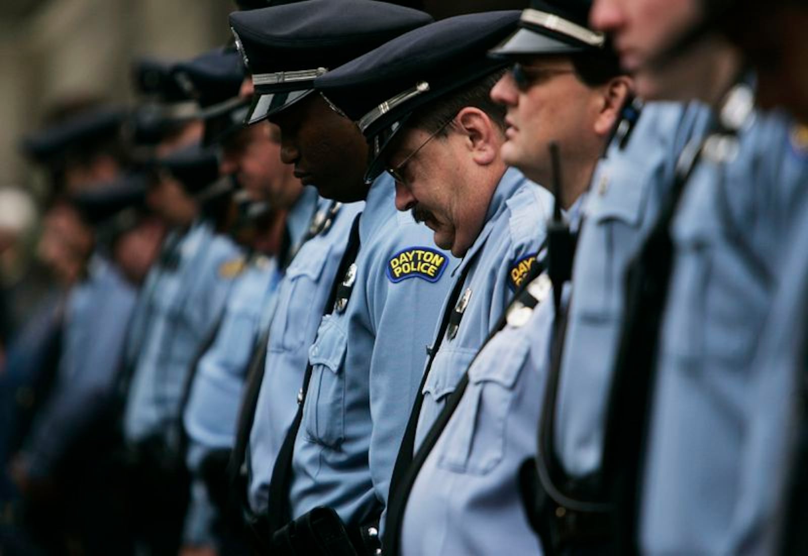 Dayton Police officers lower their heads during a Montgomery County Law Enforcement Memorial ceremony. Jim Noelker/Dayton Daily News