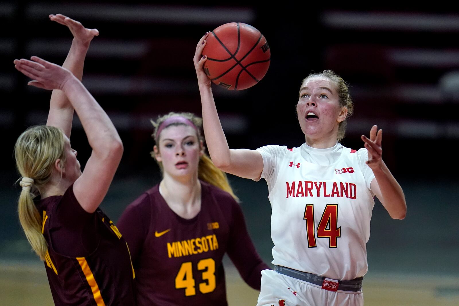 Maryland guard Taisiya Kozlova (14) goes up for a shot against Minnesota forward Erin Hedman, left, and forward Grace Cumming (43) during the second half of an NCAA college basketball game, Saturday, Feb. 20, 2021, in College Park, Md. Maryland won 94-62. (AP Photo/Julio Cortez)