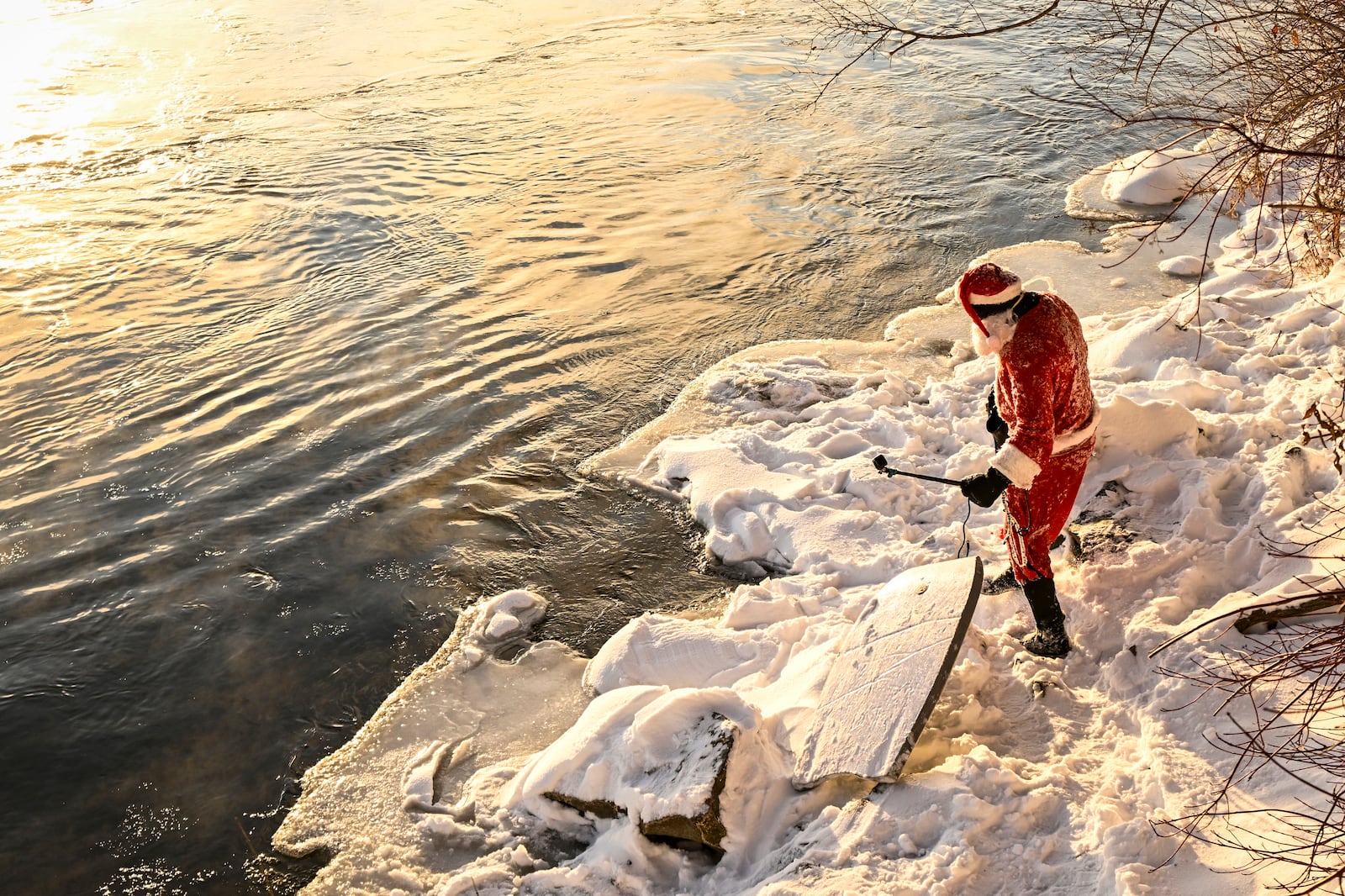 Carlos Hebert Plante, who boogie boards daily, dressed as Santa Claus gets ready to hit the St-Lawrence River amid an air temperature of -14 degrees Celsius on Christmas Day, in Montreal, Wednesday, Dec. 25, 2024. (Bernard Brault /The Canadian Press via AP)