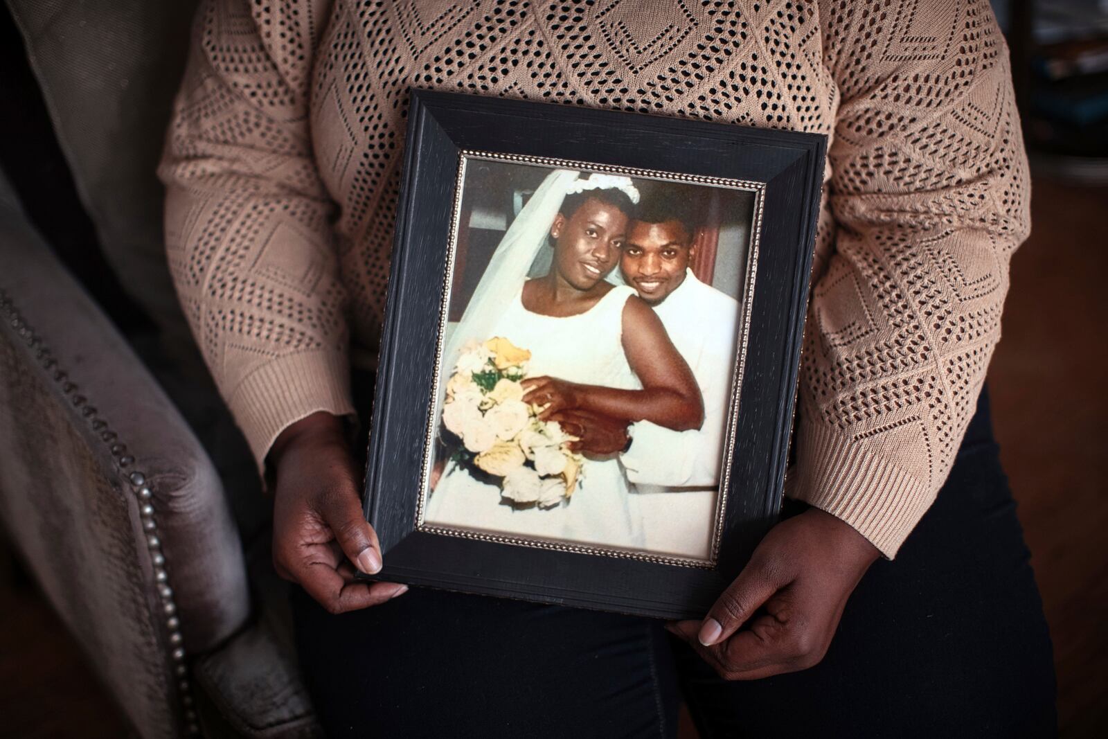 Sharline Volcy holds a photo from her wedding to Ronald Donat, on Monday, Feb. 3, 2025, in Orange, N.J. (AP Photo/Andres Kudacki)