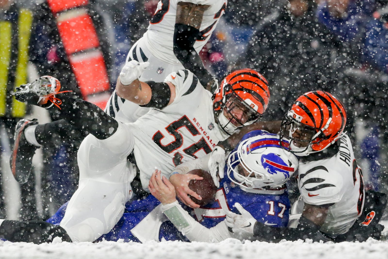 Cincinnati Bengals linebacker Logan Wilson (55) and cornerback Mike Hilton (21) bring down Buffalo Bills quarterback Josh Allen (17) during the fourth quarter of an NFL division round football game, Sunday, Jan. 22, 2023, in Orchard Park, N.Y. (AP Photo/Joshua Bessex)