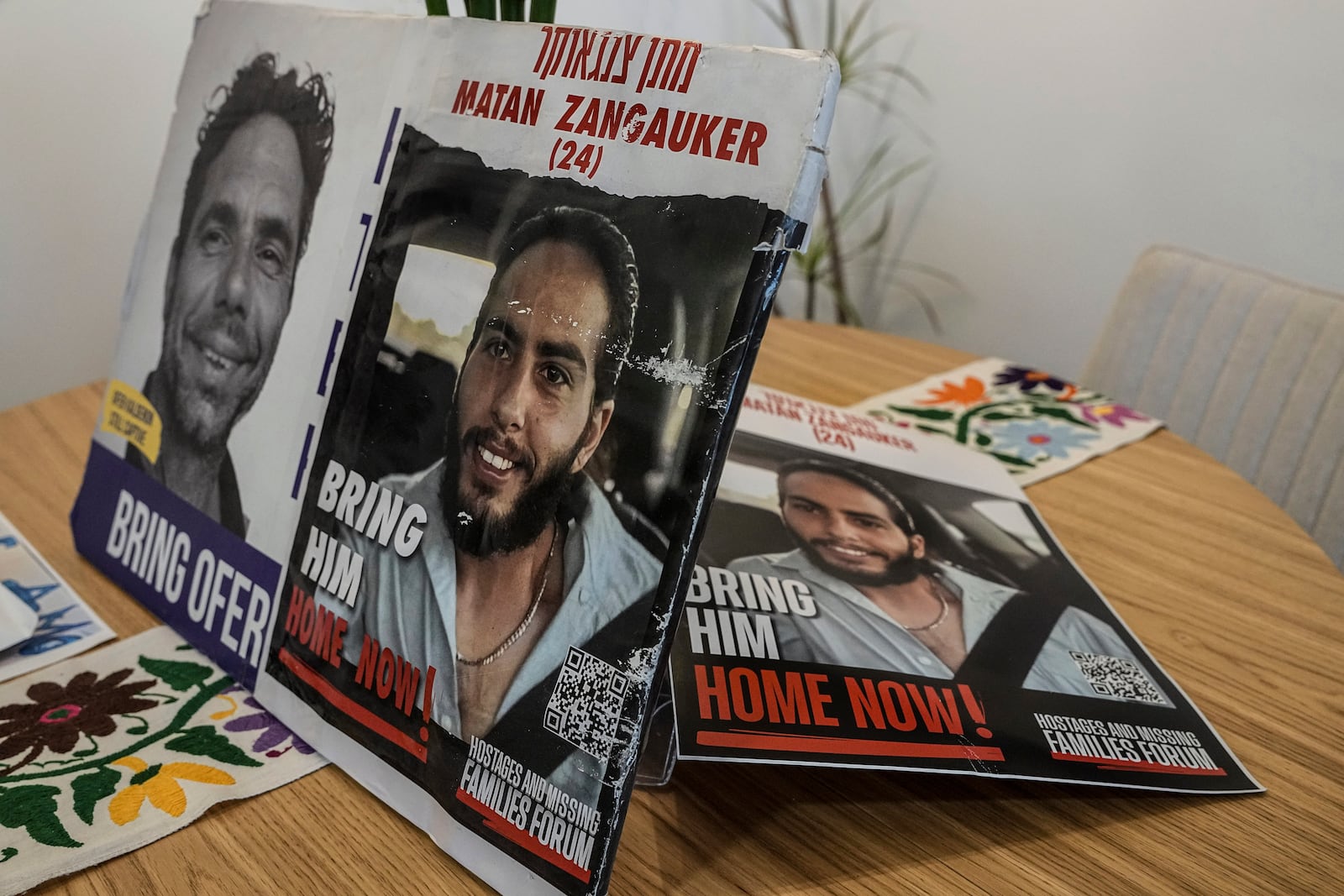 Photos of Matan Zangauker, held hostage by Hamas in the Gaza Strip, are displayed on a table in the apartment of his girlfriend, released hostage Ilana Gritzewsky, in Kiryat Gat, Israel, Sunday, Dec. 15, 2024. (AP Photo/Tsafrir Abayov)