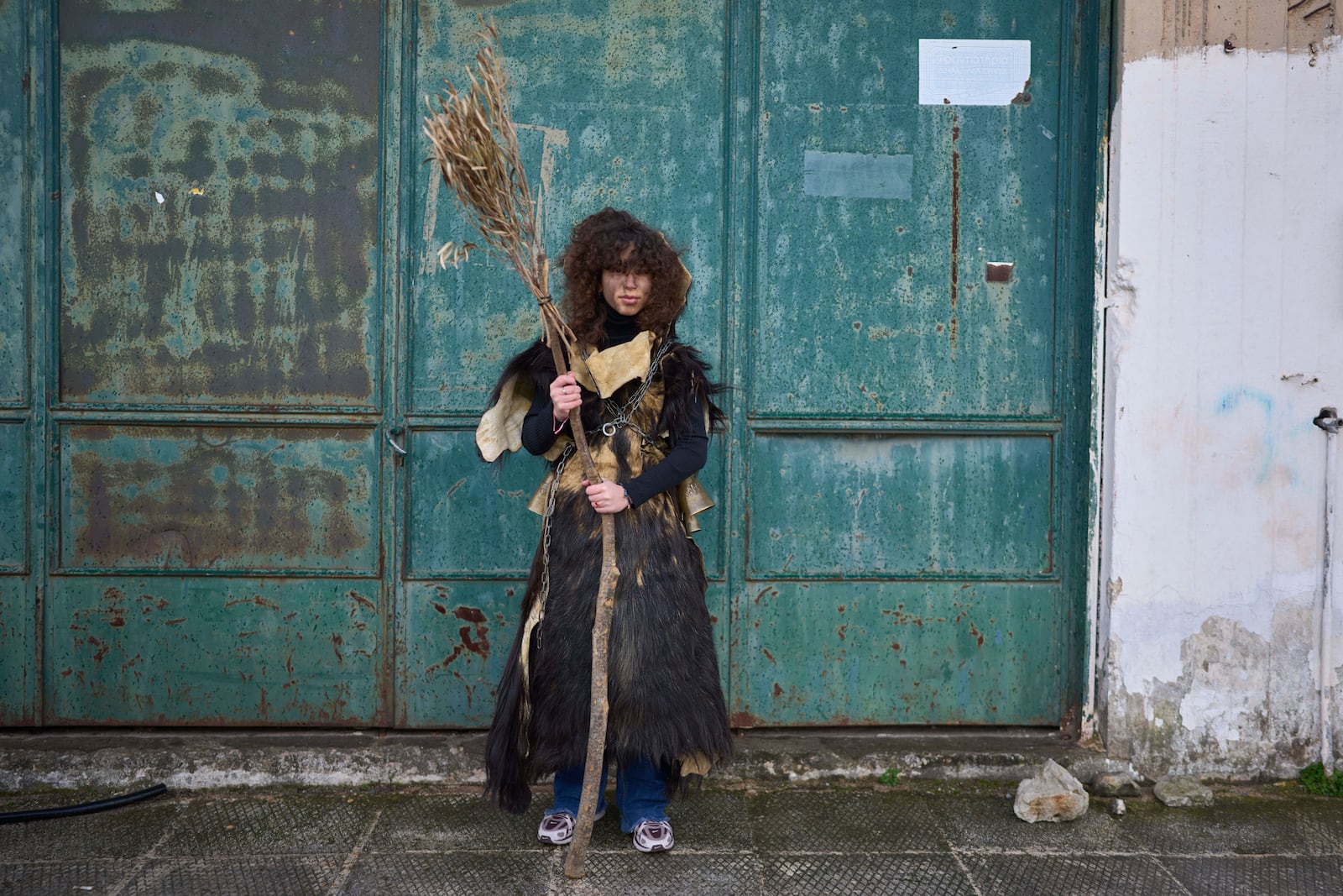 Hara Papageorgiou, 12, poses for a portrait, dressed in animal skins and heavy bronze bells, as part of carnival celebrations in Distomo, a village in central Greece, on Monday, March 3, 2025. (AP Photo/Petros Giannakouris)