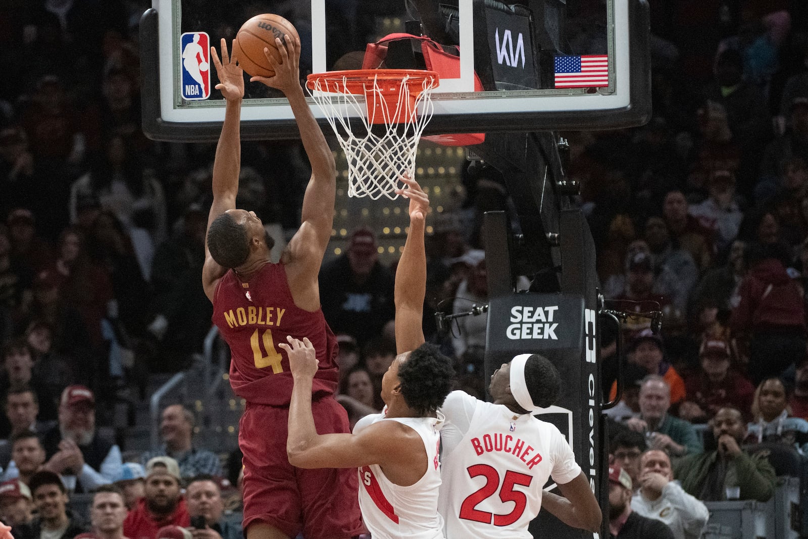 Cleveland Cavaliers' Evan Mobley (4) shoots in front of Toronto Raptors' Scottie Barnes, center, and Chris Boucher (25) during the first half of an NBA basketball game in Cleveland, Thursday, Jan. 9, 2025. (AP Photo/Phil Long)