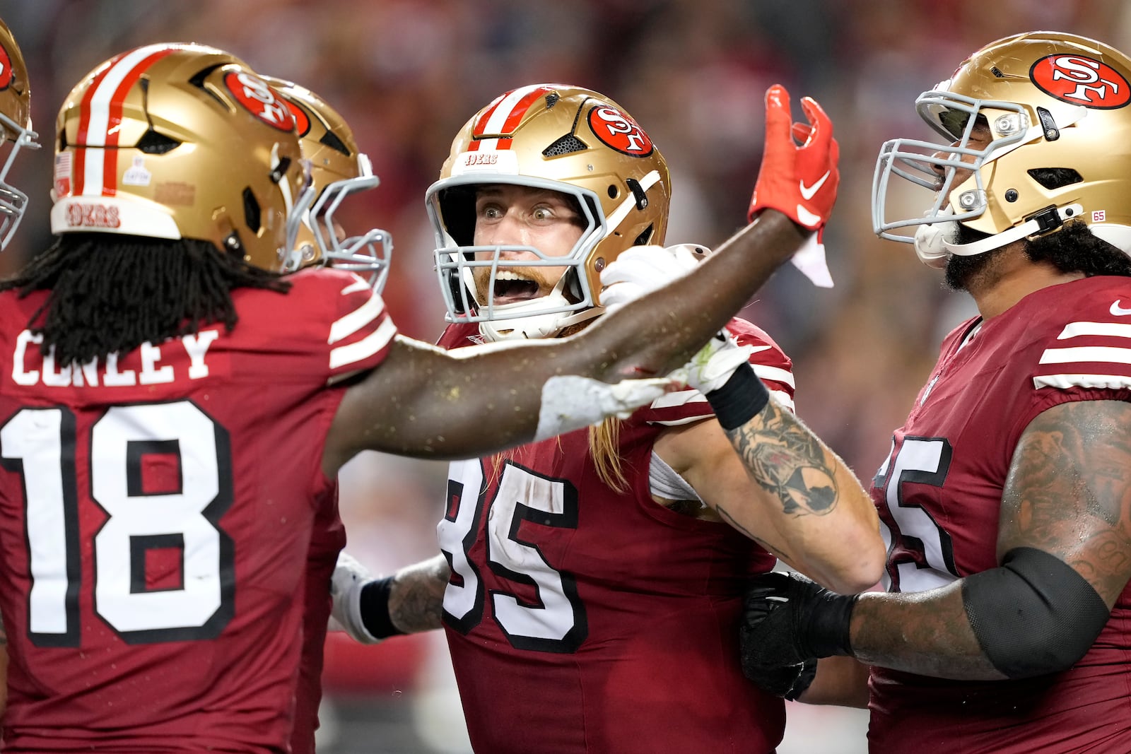 San Francisco 49ers tight end George Kittle, middle, is congratulated by wide receiver Chris Conley (18) and teammates after catching a touchdown pass against the Dallas Cowboys during the second half of an NFL football game in Santa Clara, Calif., Sunday, Oct. 27, 2024. (AP Photo/Tony Avelar)