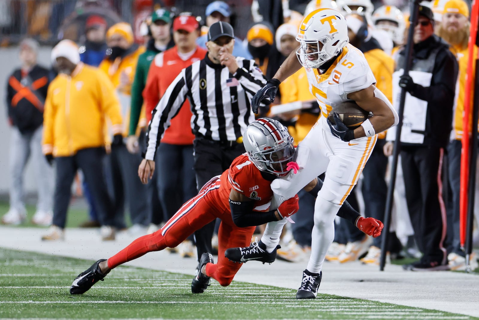 Ohio State defensive back Davison Igbinosun, left, tackles Tennessee receiver Bru McCoy, right, during the first half in the first round of the College Football Playoff, Saturday, Dec. 21, 2024, in Columbus, Ohio. (AP Photo/Jay LaPrete)