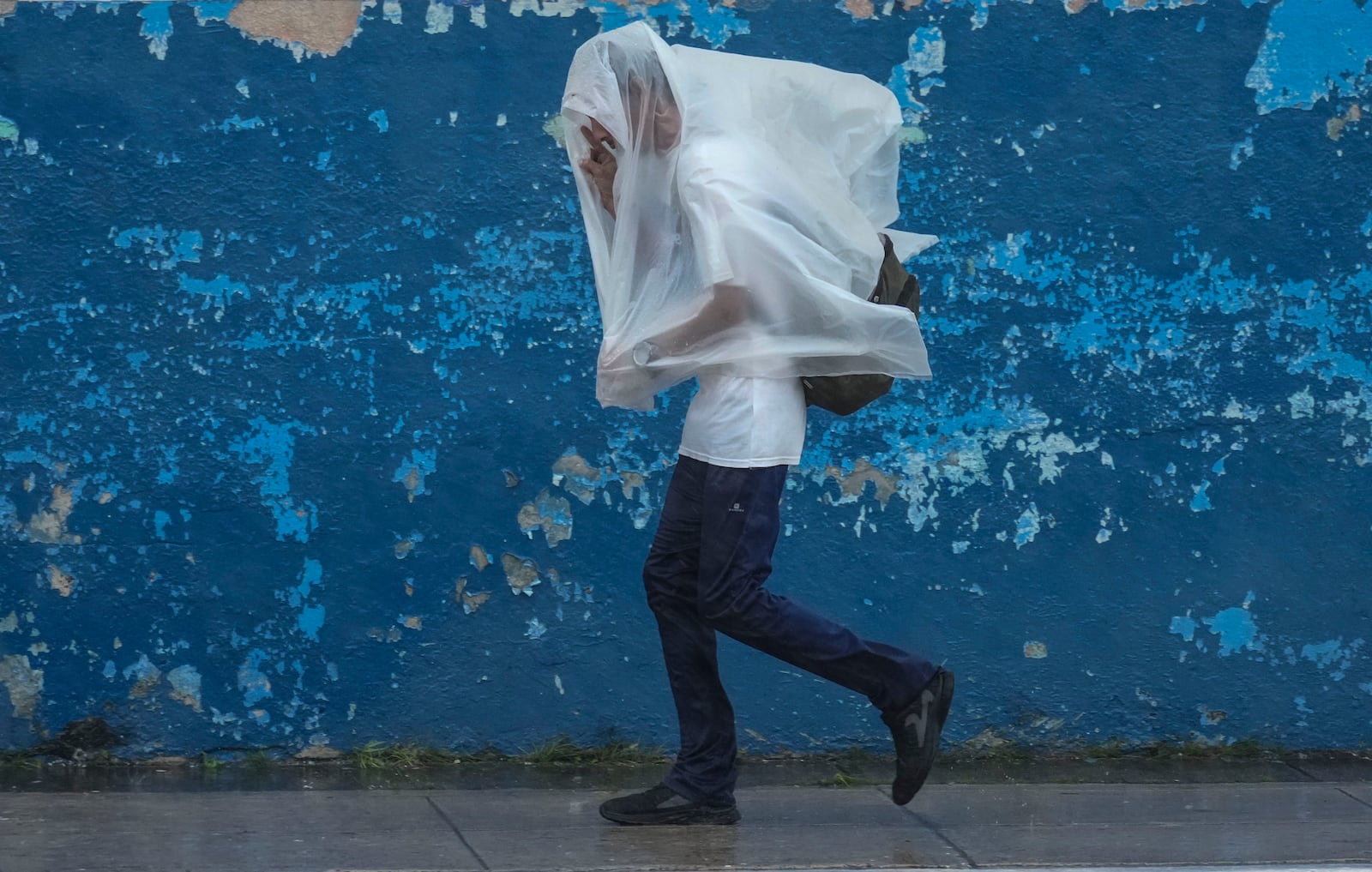 A man walks through the wind and rain brought by Hurricane Rafael in Havana, Cuba, Wednesday, Nov. 6, 2024. (AP Photo/Ramon Espinosa)