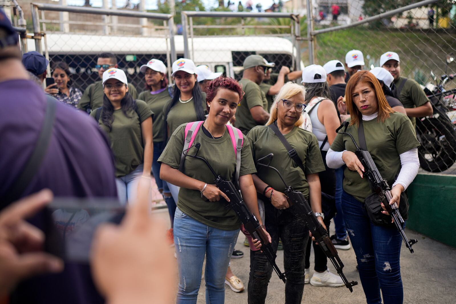 Members of government-backed militias pose with rifles prior to a march in Caracas, Venezuela, Tuesday, Jan. 7, 2025, days ahead of President Nicolas Maduro's inauguration for a third term. (AP Photo/Matias Delacroix)