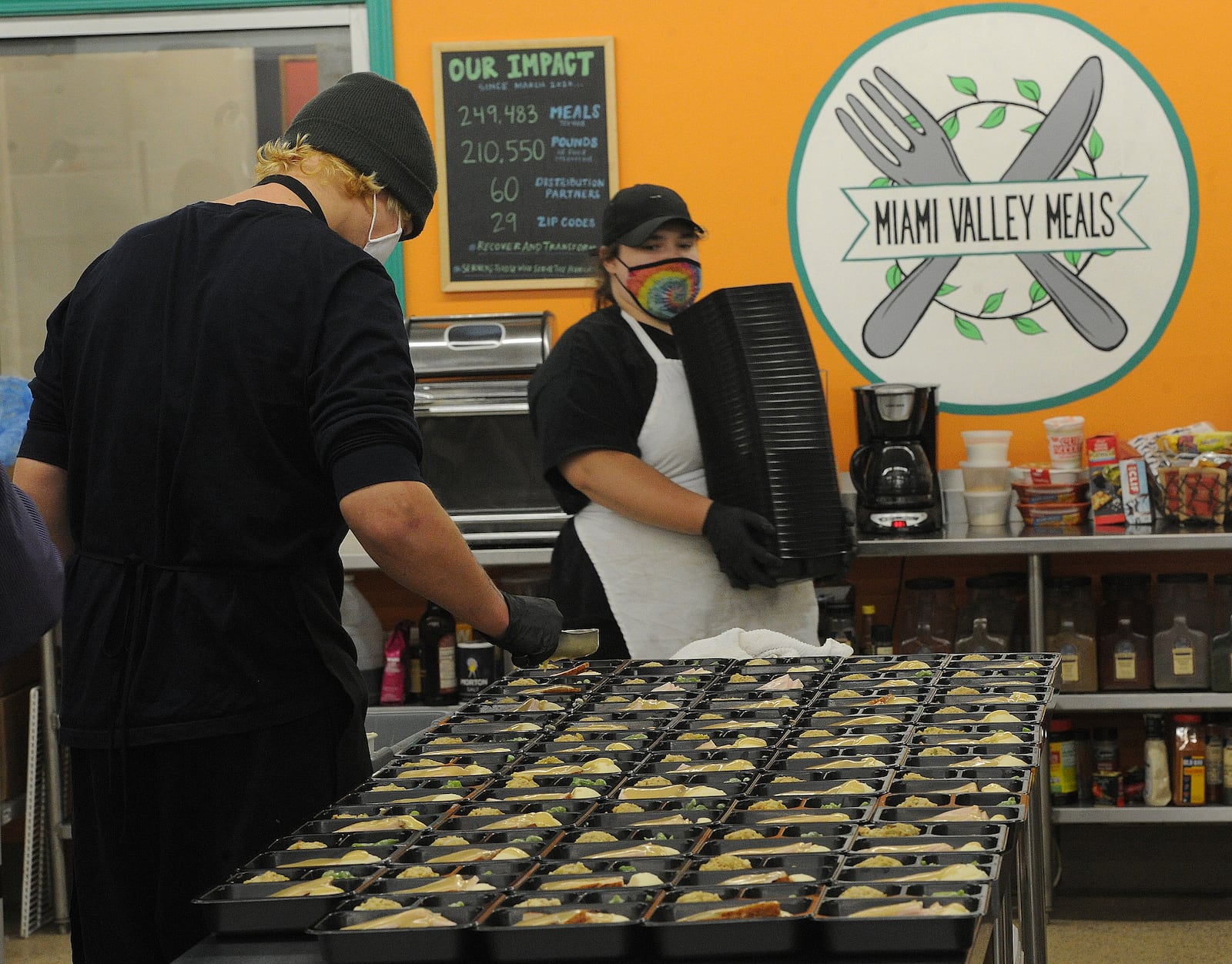 Sean Sibbing, left, and Ashley Purvis, helps Miami Valley Meals in preparing 15,000 meals for Thanksgiving. The meals include turkey, gravy, stuffing, mash potatoes, green beans and pumpkin roll. MARSHALL GORBY\STAFF