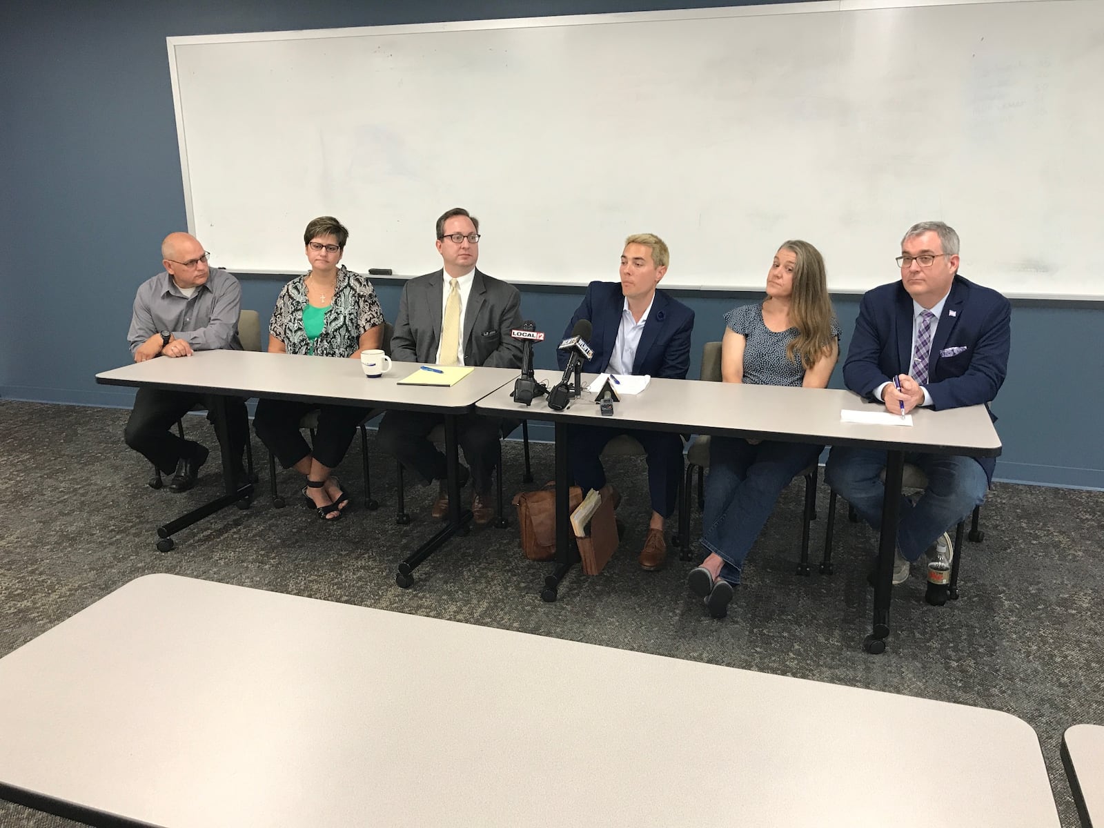 The parents of two Warren County transgender teens, with their attorneys Josh Engel and Josh Langdon (center) discuss a federal lawsuit they have filed against Warren County Juvenile and Probate Judge Joseph Kirby on Friday, Aug. 3. They want the federal court to force Kirby to grant a name change for their children who were born female but identify themselves as male. 