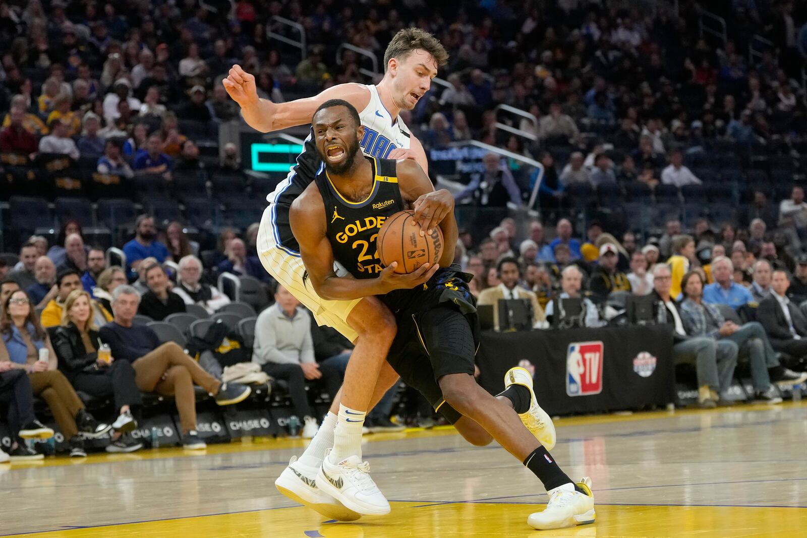 Golden State Warriors forward Andrew Wiggins, bottom, is fouled by Orlando Magic forward Franz Wagner during the second half of an NBA basketball game in San Francisco, Monday, Feb. 3, 2025. (AP Photo/Jeff Chiu)