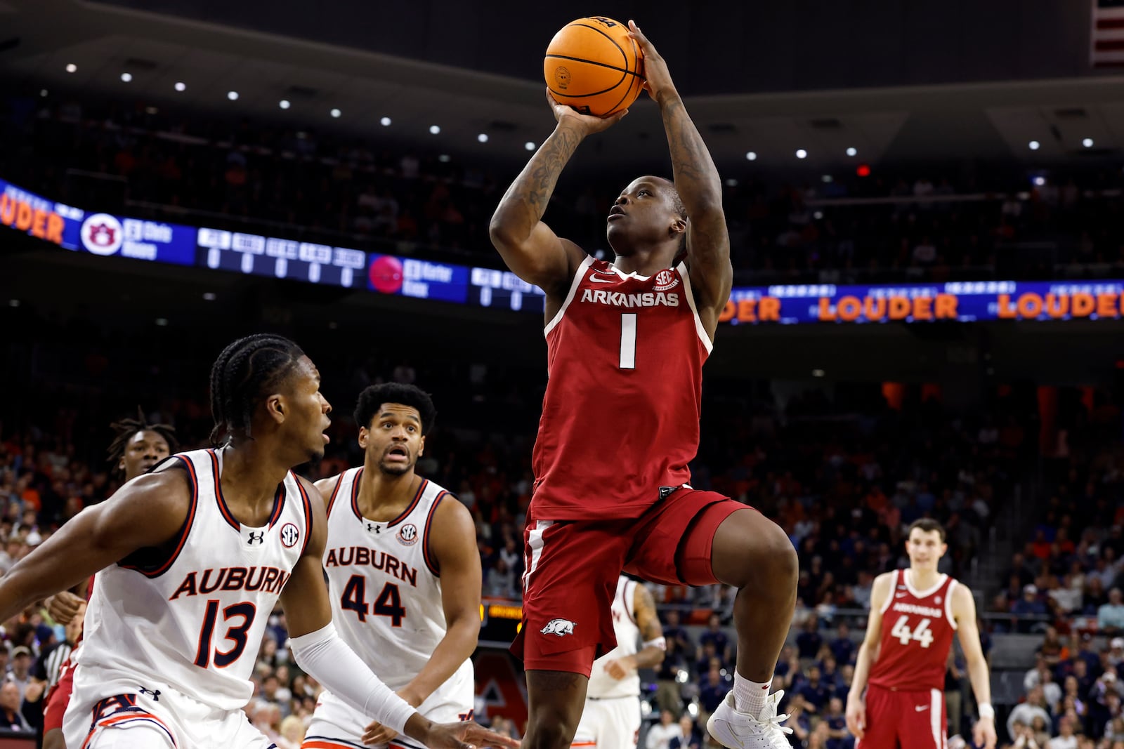 Arkansas guard Johnell Davis (1) puts up a shot over Auburn guard Miles Kelly (13) during the first half of an NCAA college basketball game, Wednesday, Feb. 19, 2025, in Auburn, Ala. (AP Photo/Butch Dill)