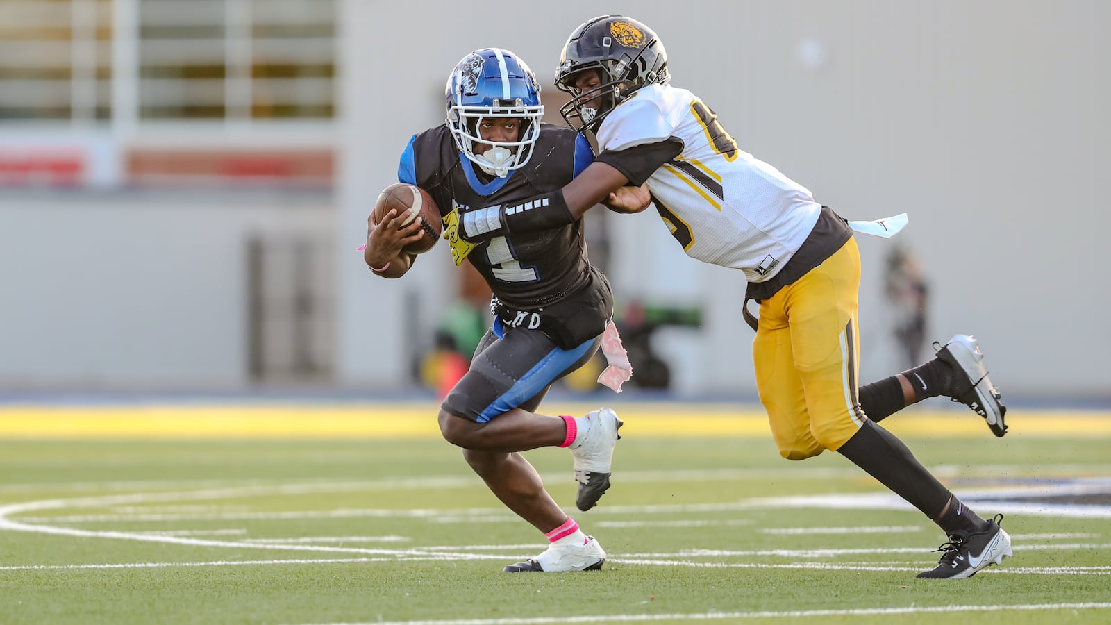 Dunbar High School junior William Wilson tries to evade Meadowdale freshman Dearonn Daniel during their game on Thursday night at Dayton Welcome Stadium. Wilson broke free and threw a touchdown pass on the play, but the Lions won 44-14. CONTRIBUTED PHOTO BY MICHAEL COOPER