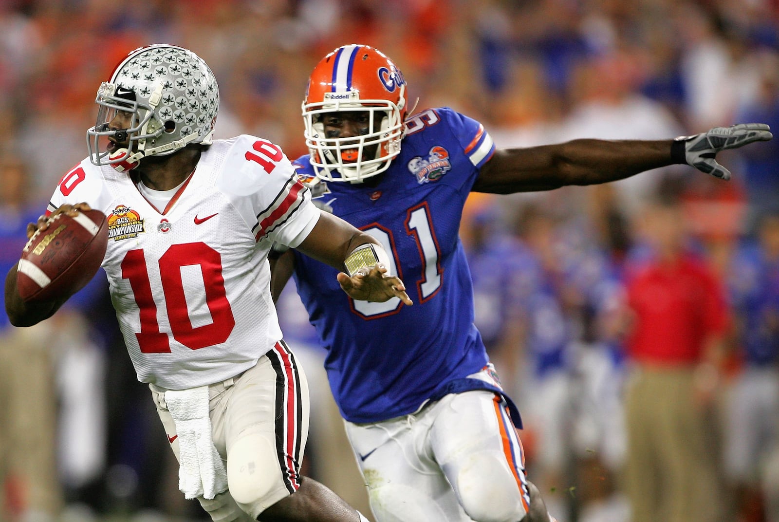 GLENDALE, AZ - JANUARY 08:  Quarterback Troy Smith #10 of the Ohio State Buckeyes scrambles with the ball under pressure from Derrick Harvey #91 of the Florida Gators during the 2007 Tostitos BCS National Championship Game at the University of Phoenix Stadium on January 8, 2007 in Glendale, Arizona.  (Photo by Doug Pensinger/Getty Images)