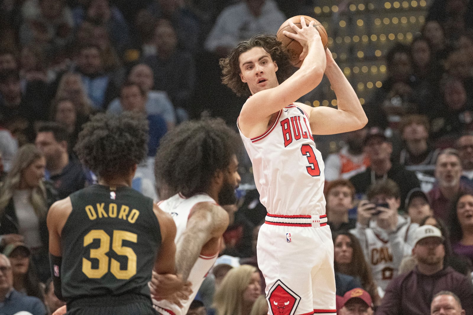 Chicago Bulls' Josh Giddey (3) hauls in a rebound as teammate Coby White, center, and Cleveland Cavaliers' Isaac Okoro (35) look on during the first half of an Emirates NBA Cup basketball game in Cleveland, Friday, Nov 15, 2024. (AP Photo/Phil Long)