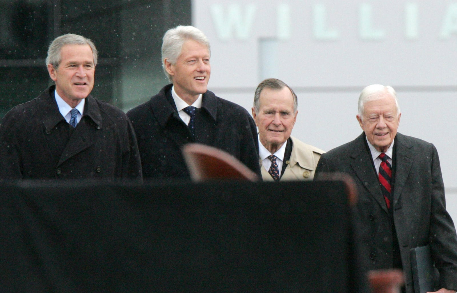 FILE - President George W. Bush, left to right, former President Bill Clinton, former President George H.W. Bush, and former President Jimmy Carter walk from the William J. Clinton Presidential Center to the podium during opening ceremonies in Little Rock, Ark., Nov. 18, 2004. (AP Photo/Ric Feld, File)