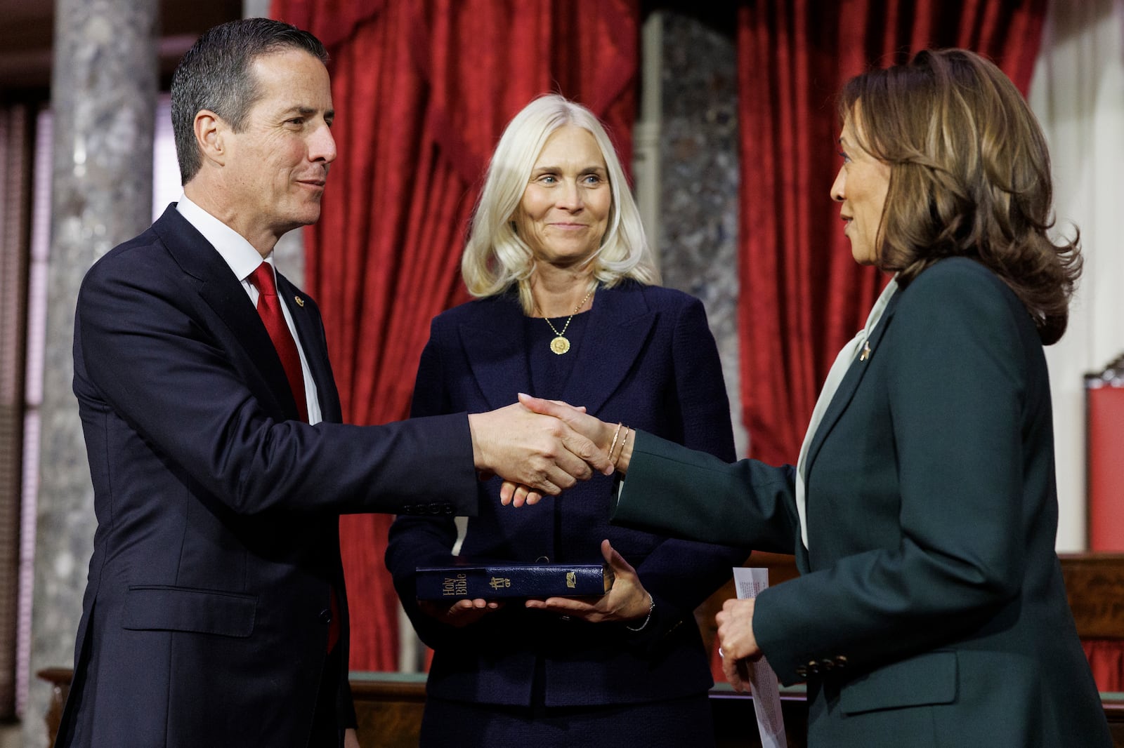 
                        Sen. Bernie Moreno (R-Ohio) shakes hands with Vice President Kamala Harris after he was ceremonially sworn in by Vice President Kamala Harris at the Capitol in Washington on Friday, Jan. 3, 2025. Looking on at center is Moreno’s wife, Bridget. (Tom Brenner/The New York Times)
                      