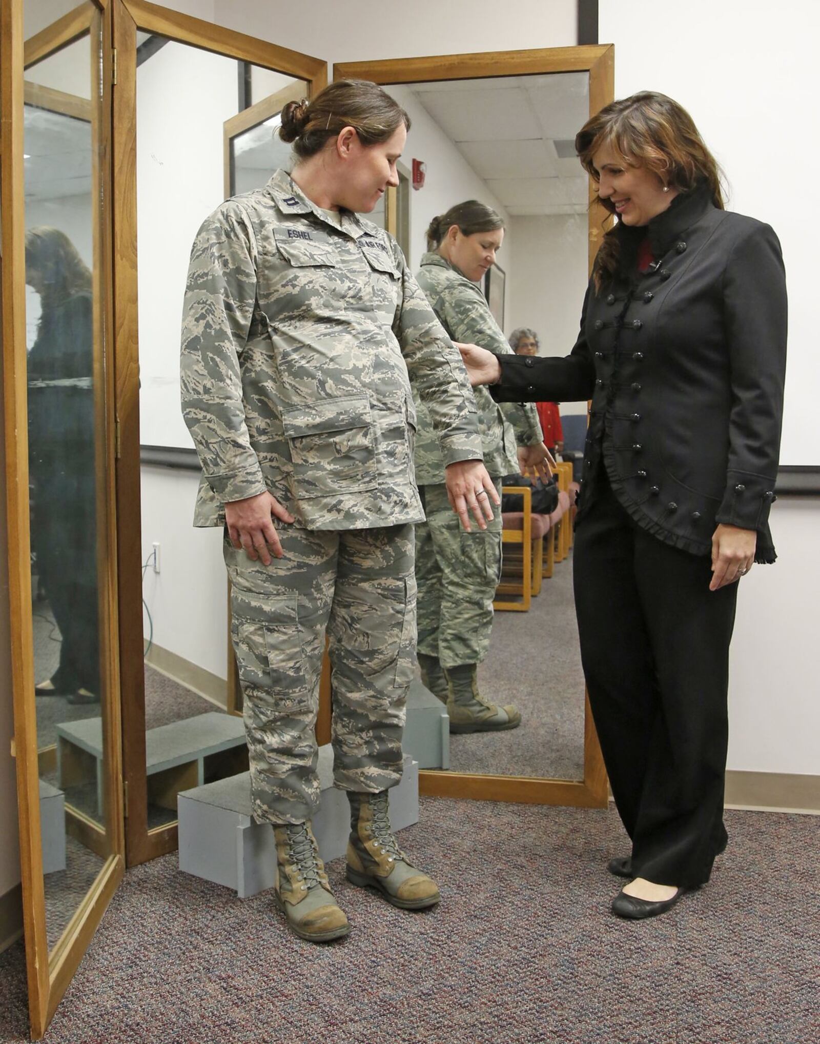 Air Force Uniform Office clothing designer Stacey Butler, right, inspects an improved maternity uniform prototype which is being tested by Capt. Mollie Eshel, left, who is in her 38th week of pregnancy and works at the Air Fore Research Lab at Wright-Patterson Air Force Base. TY GREENLEES / STAFF