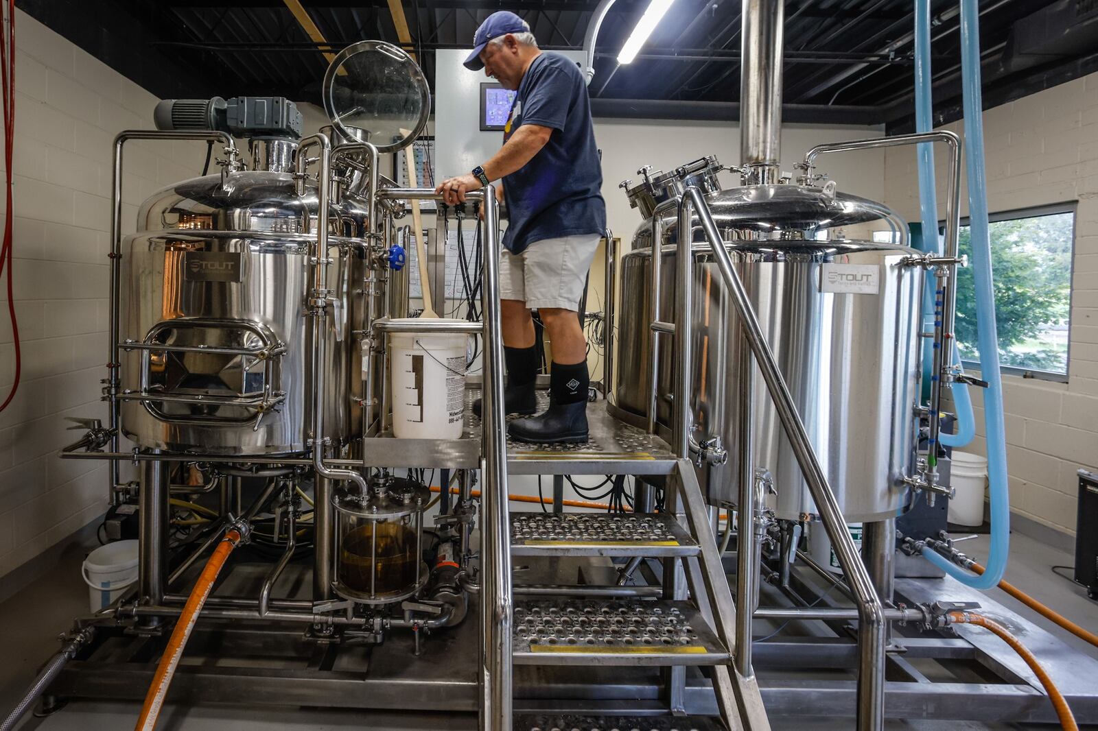 James Williams, co-owner of Southern Ohio Brewing in Beavercreek, checks the brewing tank at the brewery Monday September 12, 2022. Williams is a retired school teacher. JIM NOELKER/STAFF