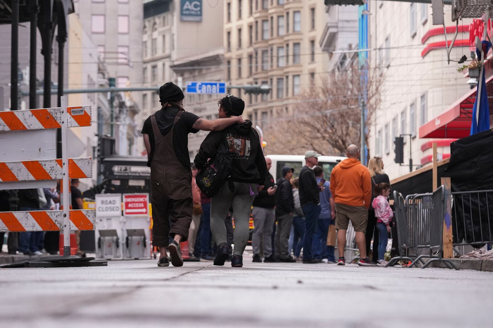 People visit a memorial for victims of the Jan. 1 car attack where newly installed security barriers have since been put in place on Bourbon Street ahead of the Super Bowl in New Orleans, Friday, Jan. 31, 2025. (AP Photo/Gerald Herbert)