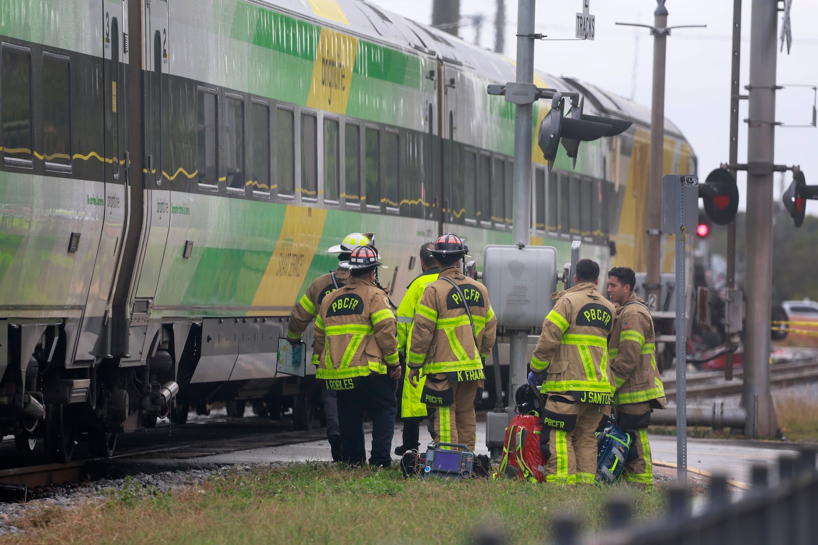 Firemen gather after Brightline train collided with a fire truck in downtown Delray Beach, Fla., Saturday, Dec. 28, 2024. (Mike Stocker/South Florida Sun-Sentinel via AP)