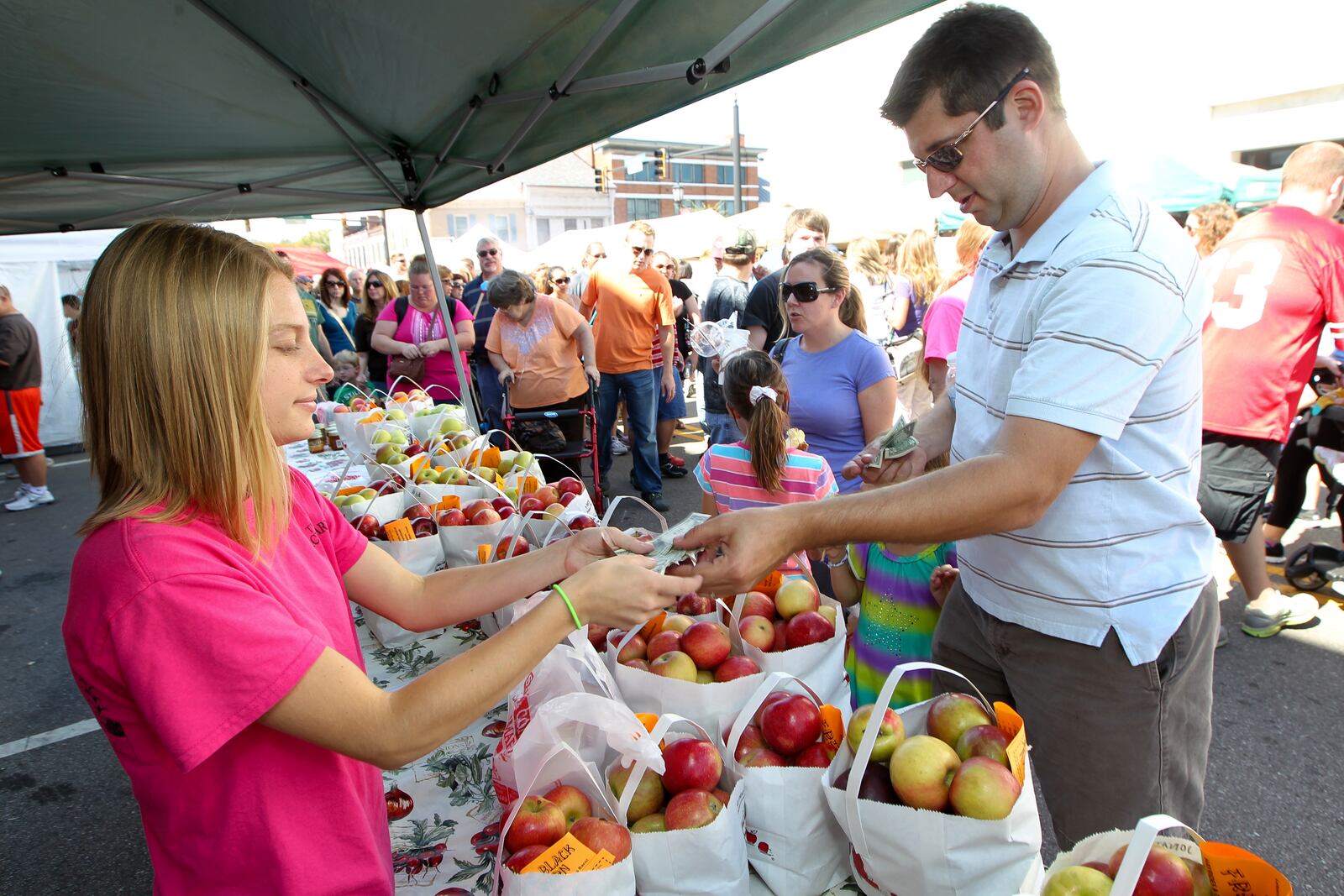 Brian Hesseling purchases apples from Amanda Santel at the Black Barn booth during the Country Applefest in downtown Lebanon Saturday, Sept. 28, 2013. NICK DAGGY / STAFF