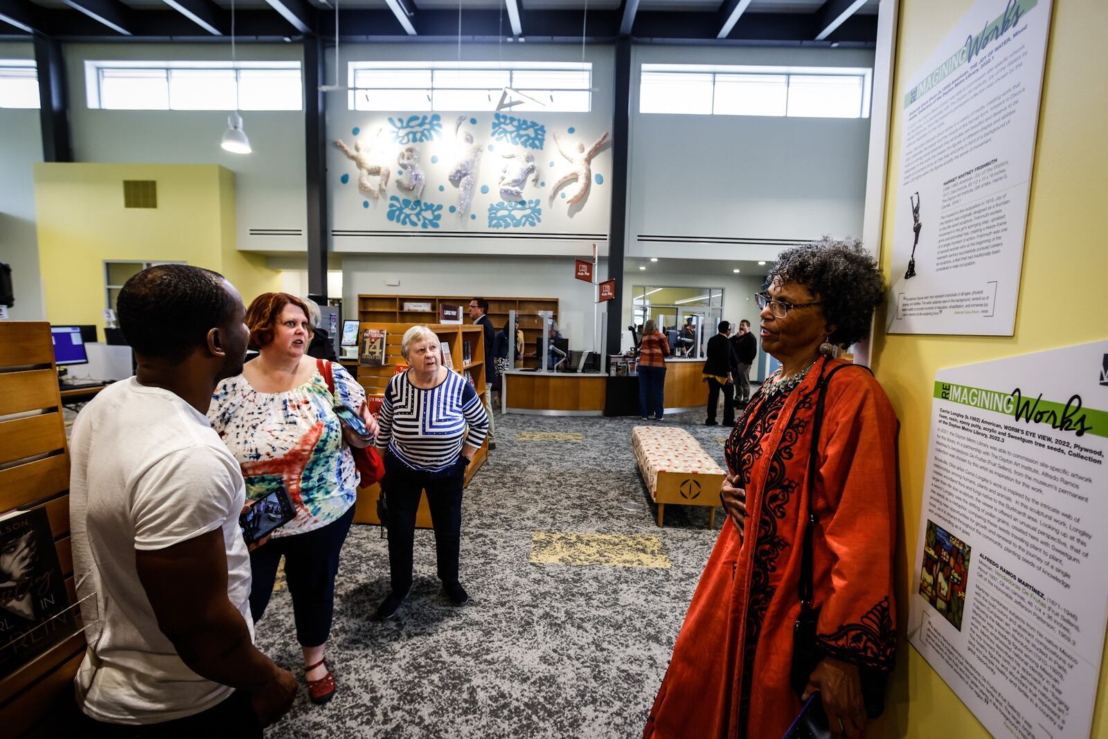 Local artist, Deborah Dixon fields questions about her sculpture that hangs in the newly opened Burkhardt Branch Library Monday April 25, 2022. JIM NOELKER/STAFF