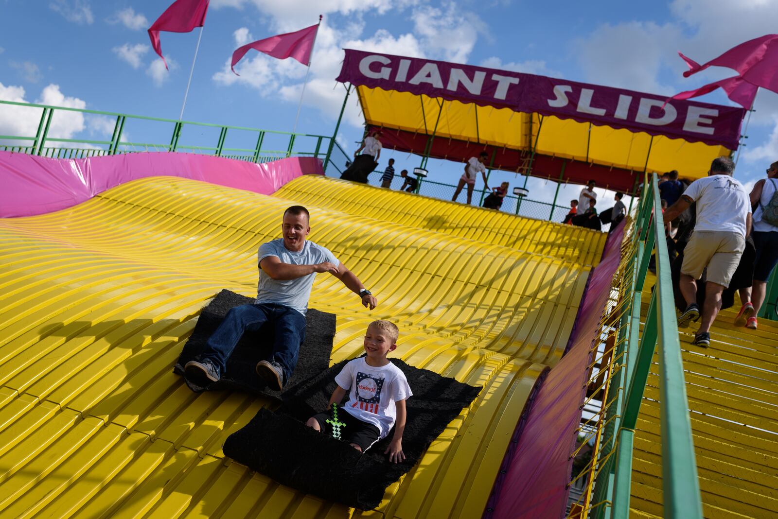 Fair-goers enjoy the thrills of going down the 144-ft giant slide