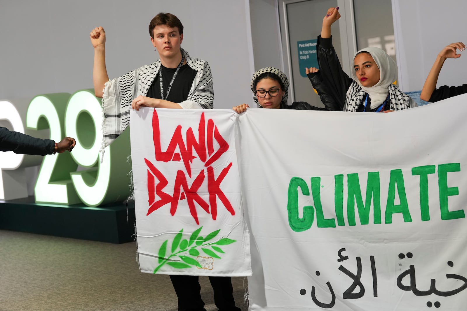 Activists demonstrate for climate justice and a ceasefire in the Israel-Hamas at the COP29 U.N. Climate Summit, Monday, Nov. 11, 2024, in Baku, Azerbaijan. (AP Photo/Peter Dejong)