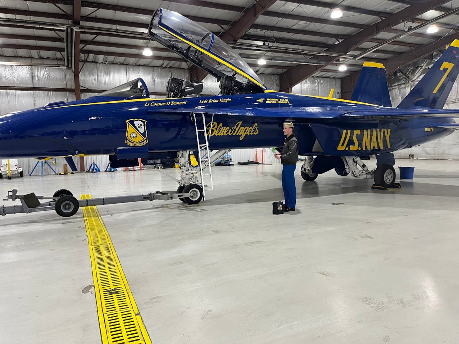 Navy Lt. Connor O’Donnell stands next to his Blue Angels F/A-18 Super Hornet in a Dayton International Airport hangar Tuesday. THOMAS GNAU/STAFF