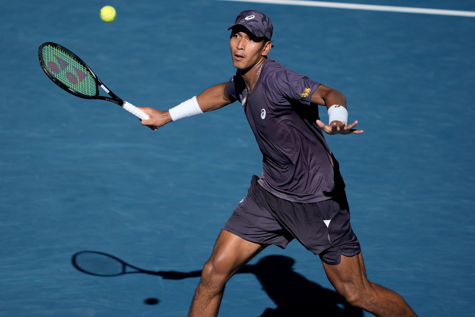 Kasidit Samrej of Thailand plays a forehand return to Daniil Medvedev of Russia during their first round match at the Australian Open tennis championship in Melbourne, Australia, Tuesday, Jan. 14, 2025. (AP Photo/Ng Han Guan)