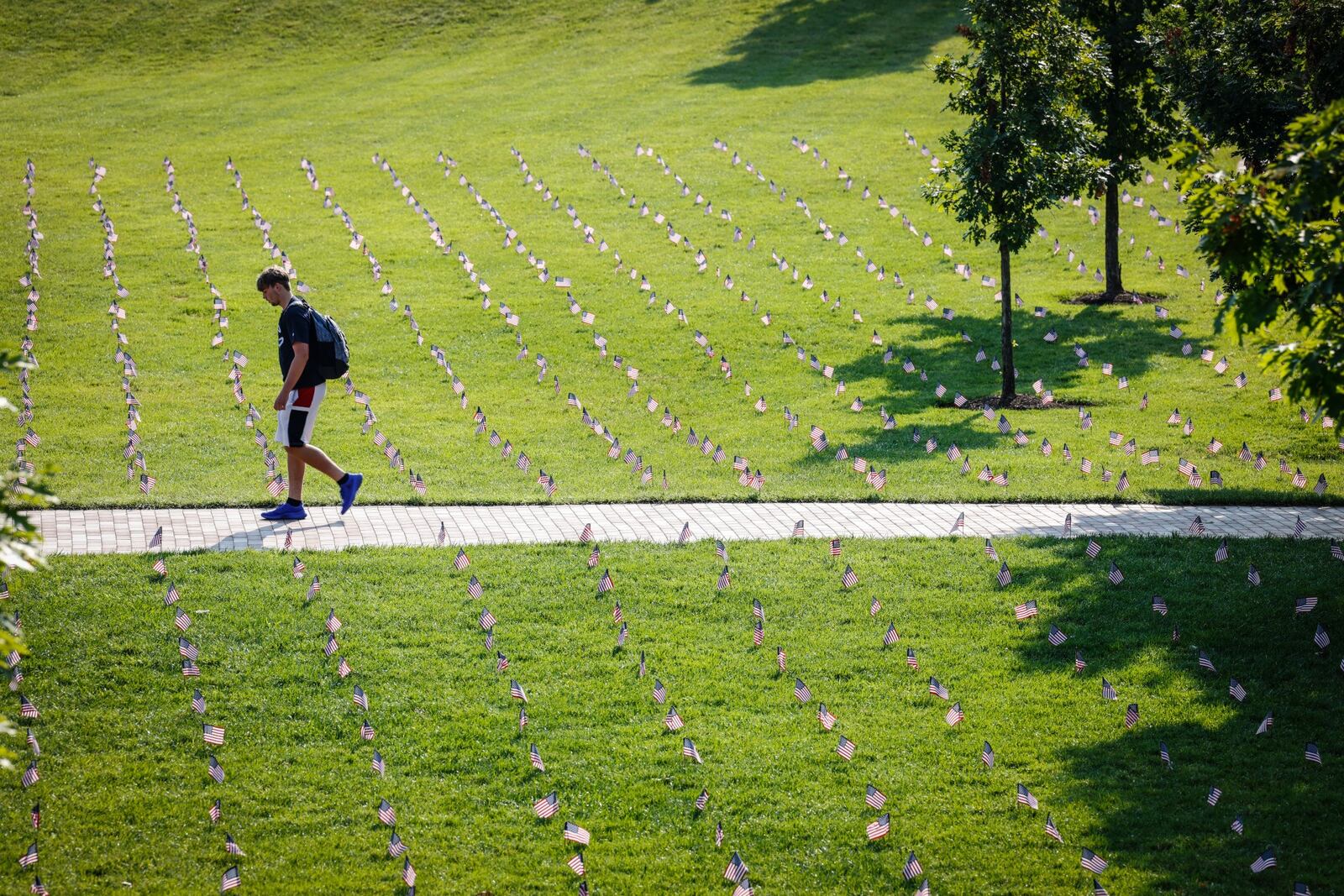 A students walks through a sea of flags on the UD Central Mall Friday in memory of the 3000 people who lost their lives on 911 twenty years ago. JIM NOELKER/STAFF