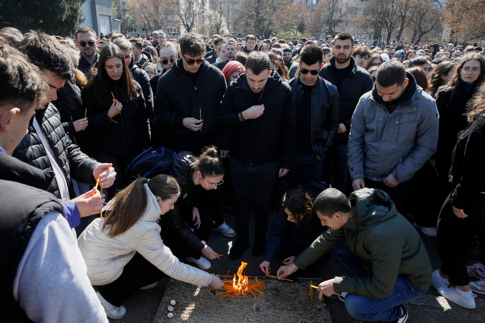 University students light candles for the victims of a massive nightclub fire in the town of Kocani, in Skopje, North Macedonia, Tuesday, March 18, 2025. (AP Photo/Boris Grdanoski)