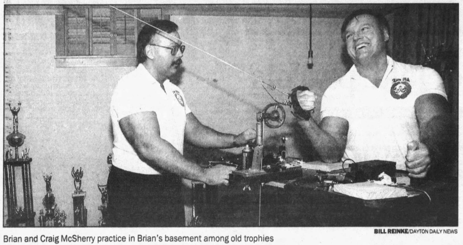 Brian and Craig McSherry practice in Brian's basement among old trophies. BILL REINKE/STAFF