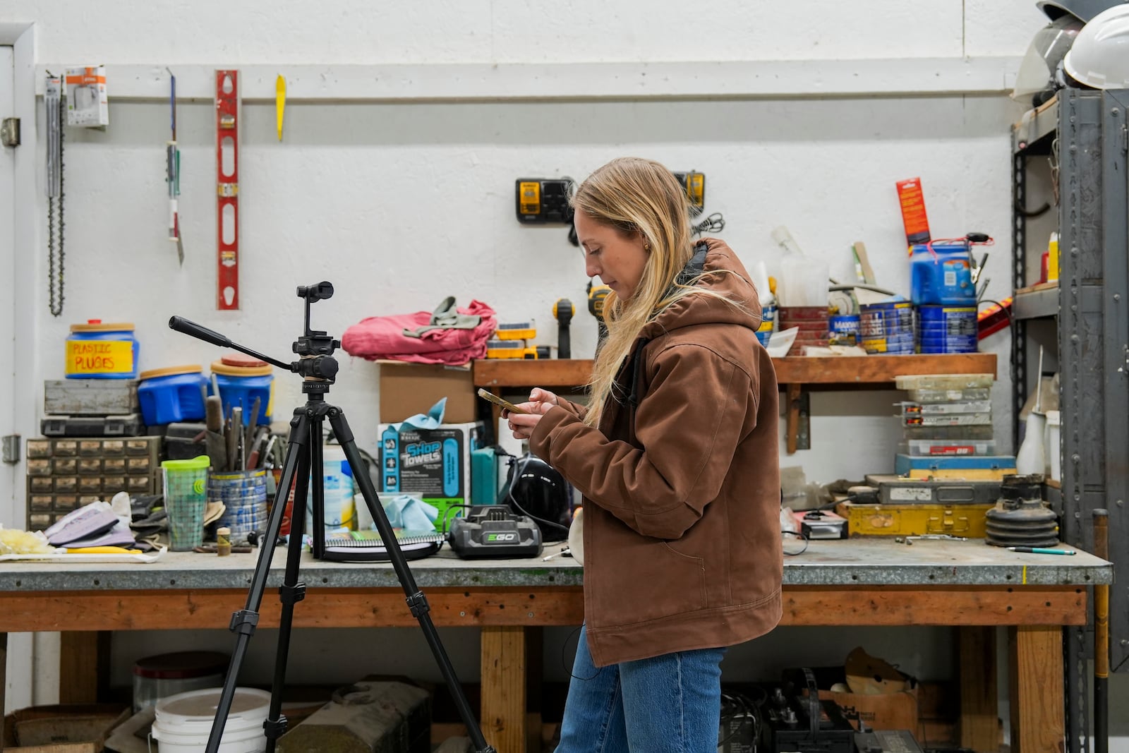 Zoe Kent stands inside her machine shop while editing a social media video on the TikTok app, Monday, Jan. 20, 2025, at her farm in Bucyrus, Ohio. (AP Photo/Joshua A. Bickel)