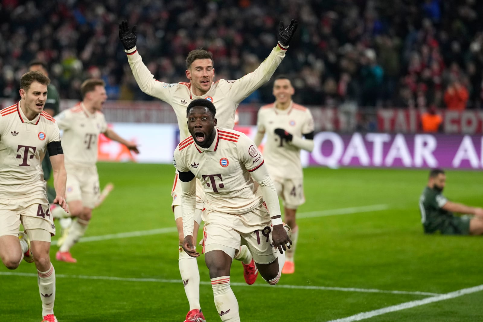 Bayern's Alphonso Davies, centre, celebrates after scoring his side's opening goal during the Champions League playoff second leg soccer match between FC Bayern Munich and Celtic Glasgow at the Allianz Arena in Munich, Germany, Tuesday, Feb. 18, 2025. (AP Photo/Matthias Schrader)