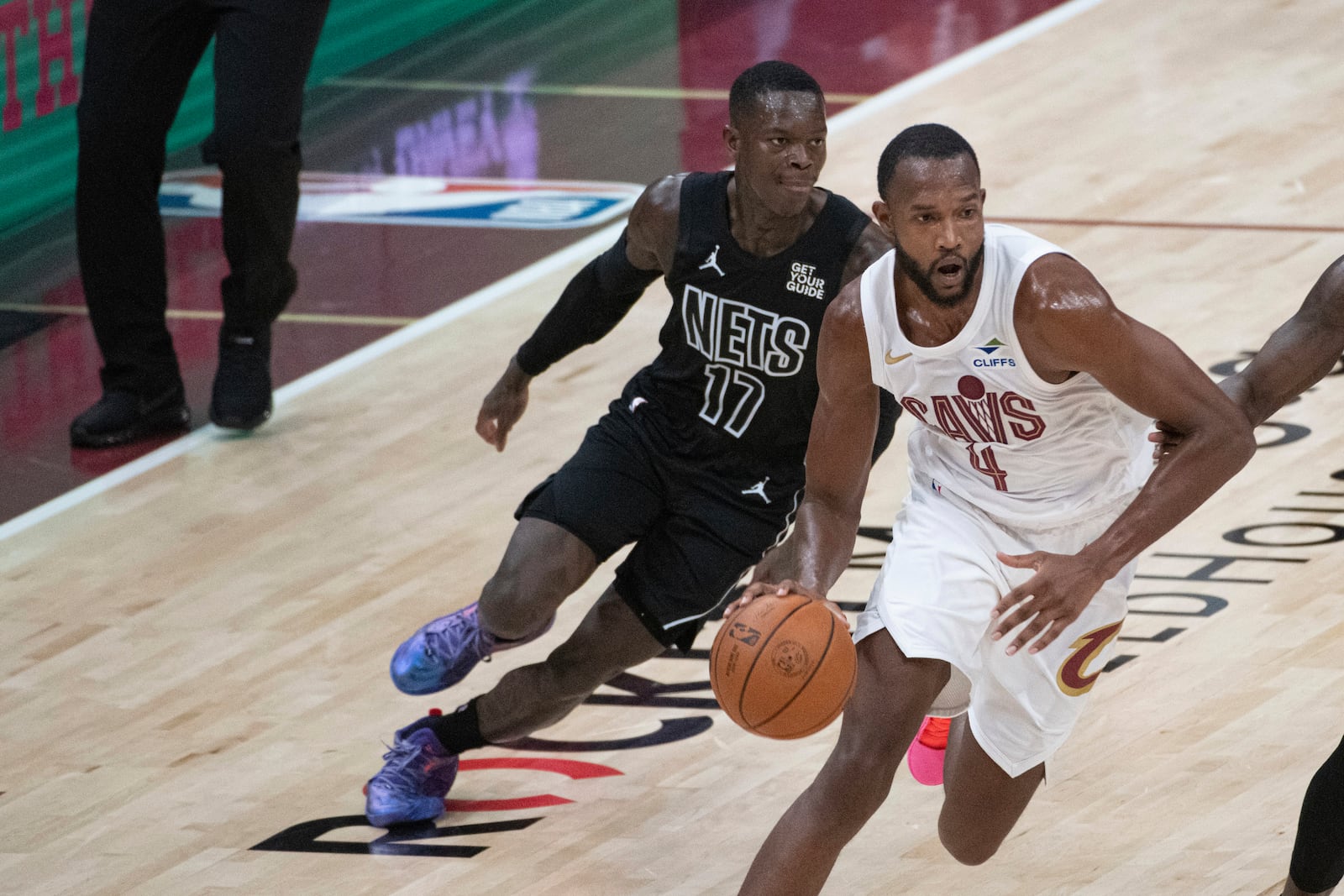 Cleveland Cavaliers' Evan Mobley (4) drives past Brooklyn Nets' Dennis Schroder (17) during the first half of an NBA basketball game in Cleveland, Saturday, Nov. 9, 2024. (AP Photo/Phil Long)