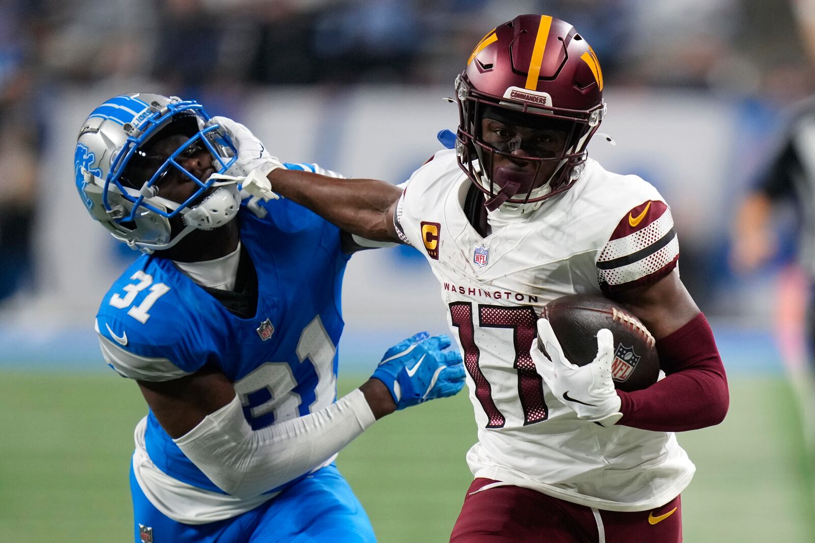 Washington Commanders wide receiver Terry McLaurin (17) stiff arms Detroit Lions safety Kerby Joseph (31) on a 58-yard touchdown reception during the first half of an NFL football divisional playoff game, Saturday, Jan. 18, 2025, in Detroit. (AP Photo/Seth Wenig)