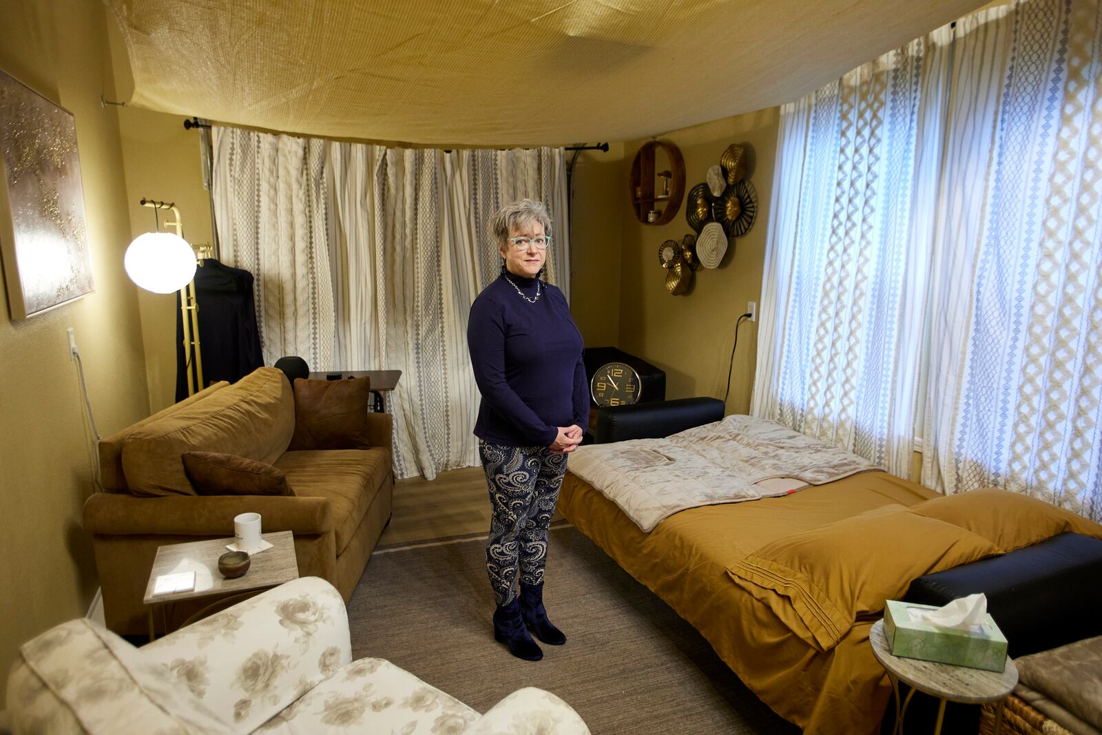 MJ Wilt, a licensed psilocybin facilitator and the owner of a licensed psilocybin service center, poses in a room setup for a patient journey at her facility in Gresham, Ore., Monday, Nov. 18, 2024. (AP Photo/Craig Mitchelldyer)